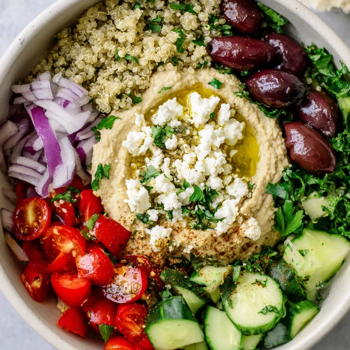 Colorful Mediterranean Hummus Bowl topped with feta, Kalamata olives, and a drizzle of olive oil.
