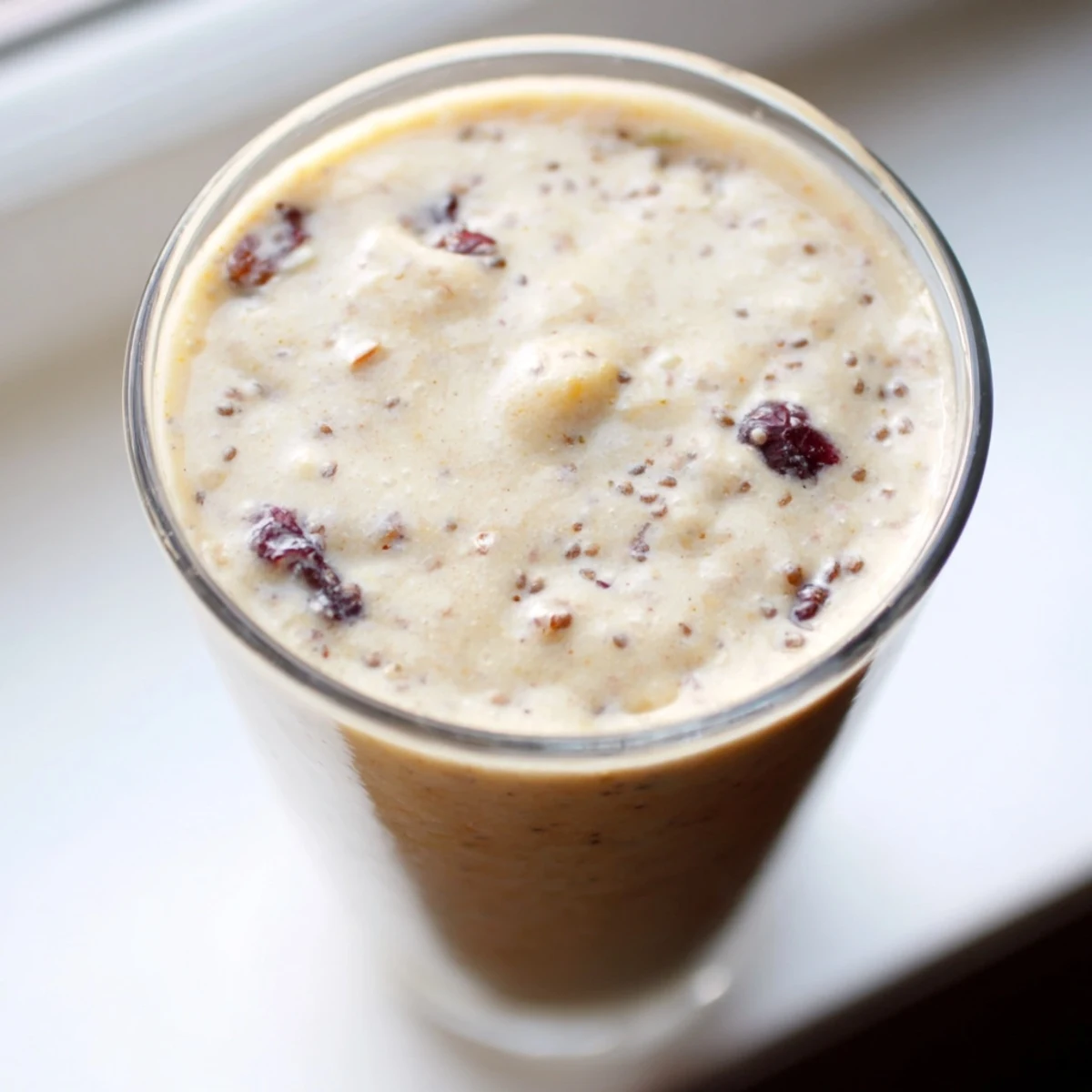 Frothy Winter Smoothie Blend with cinnamon and apple in a glass, topped with granola for a hearty breakfast.