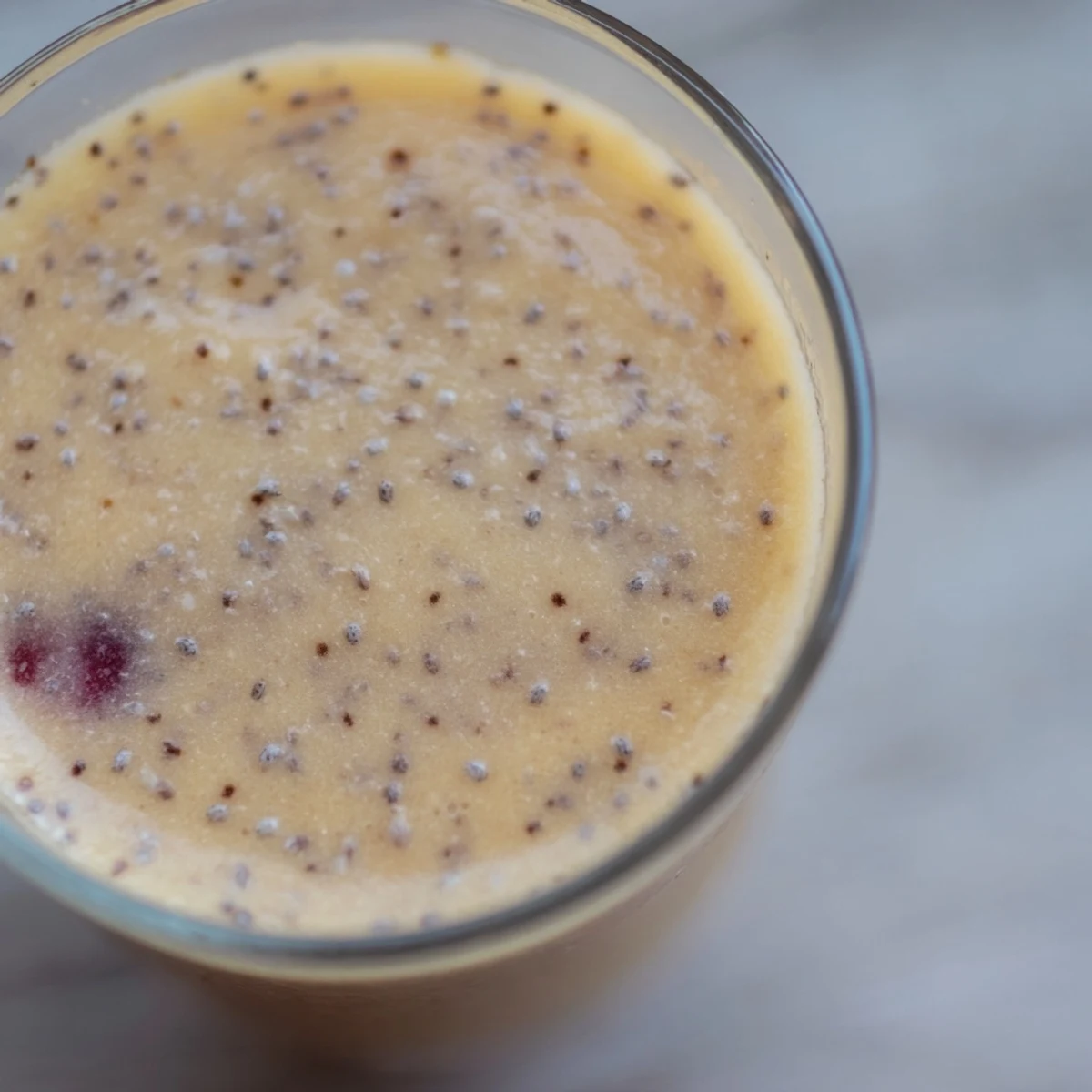 Two glasses of vibrant Winter Smoothie Blend topped with sliced fruit and chia seeds, ready for a healthy snack.