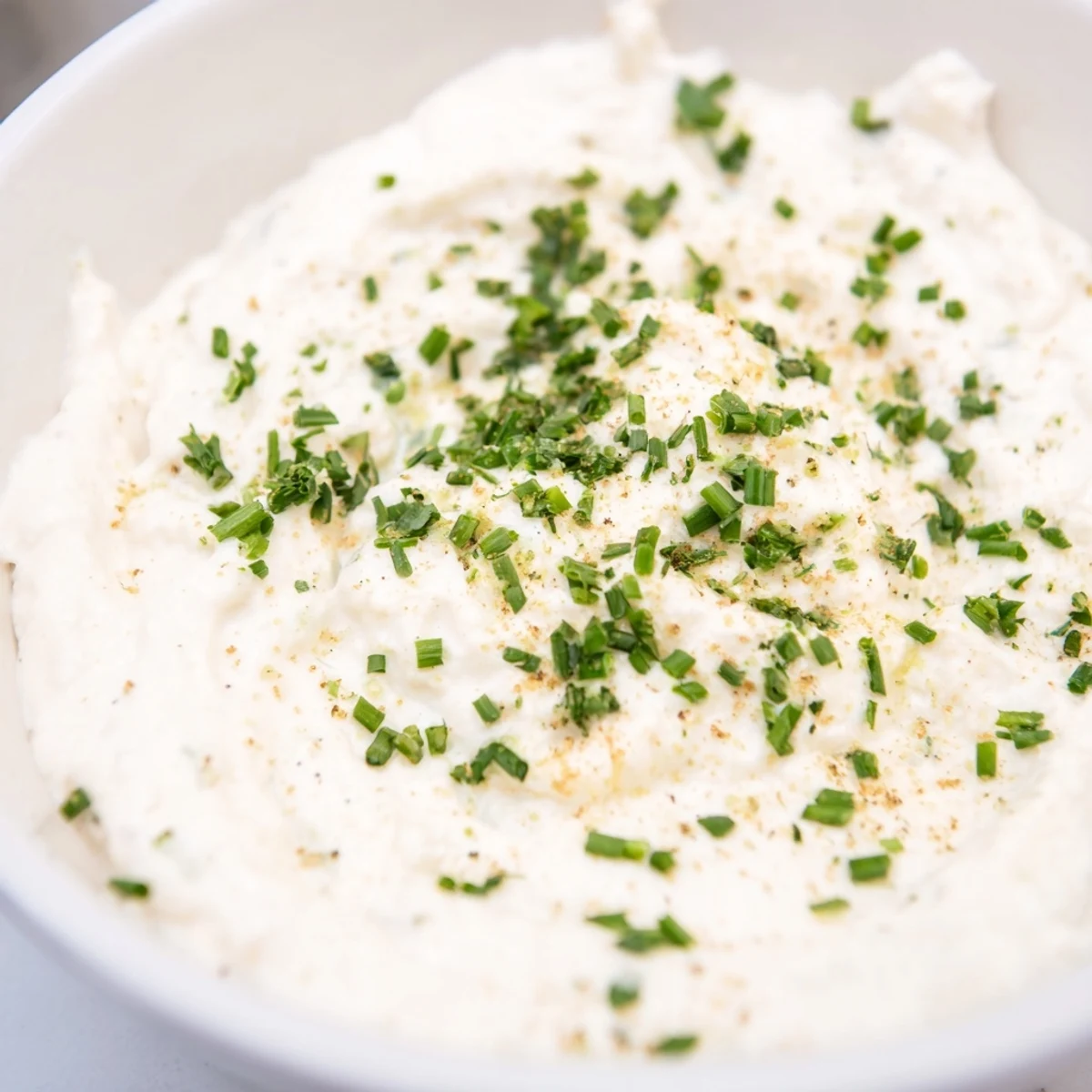 Freshly prepared Creamy Snack Dip in a white serving bowl, paired with colorful veggie sticks and crackers.