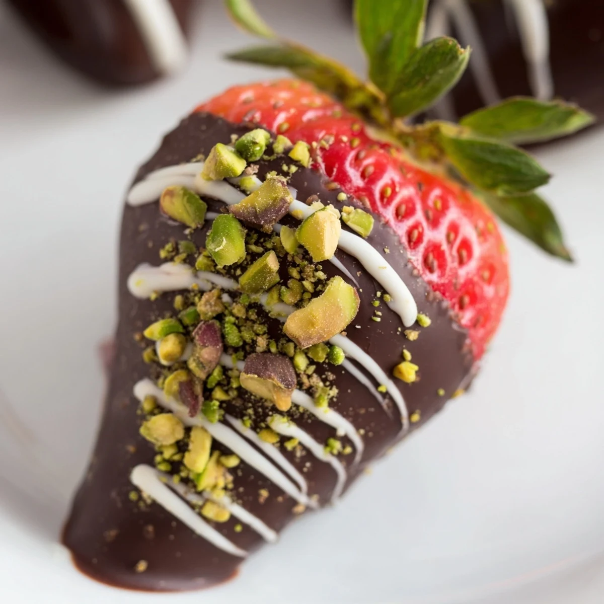Fresh strawberries, banana slices, and kiwi chunks dipped in rich dark chocolate, garnished with pistachios and coconut flakes on a baking sheet.