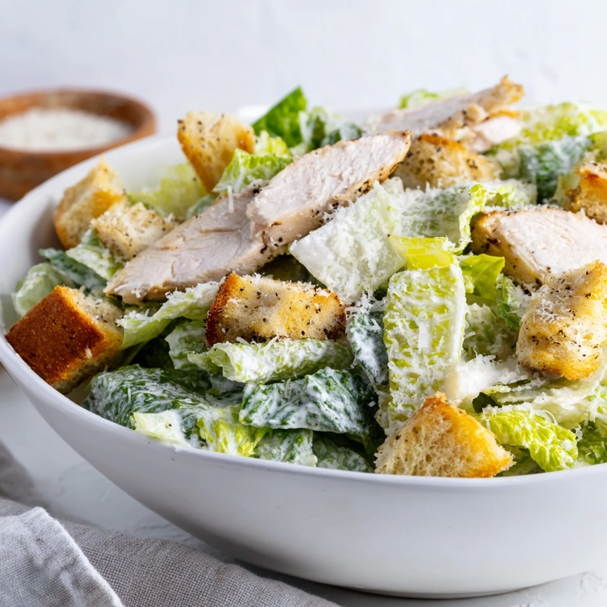 Freshly grilled chicken slices rest atop crisp romaine lettuce for this Chicken Caesar Salad with Homemade Croutons.