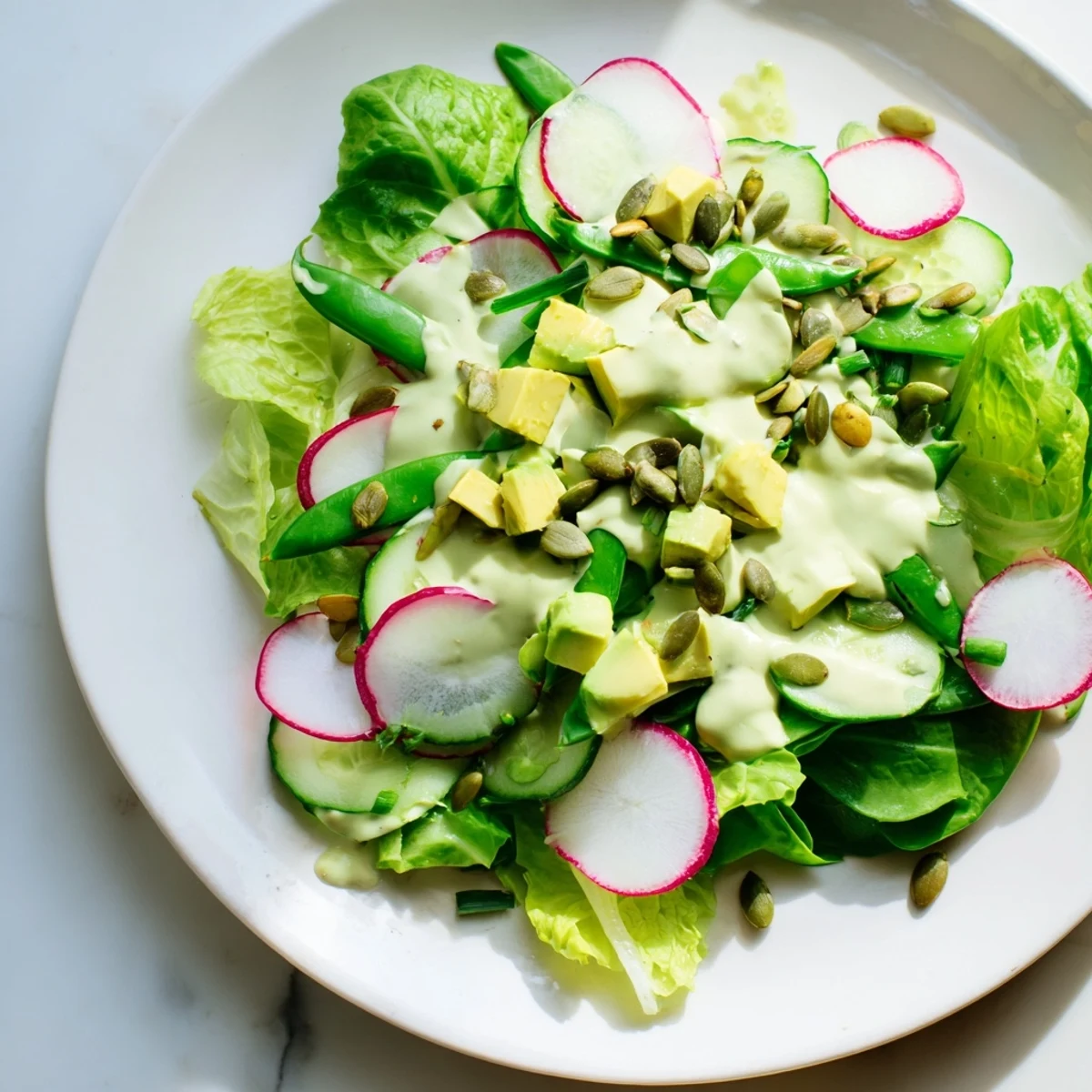 Freshly diced avocado and crisp romaine lettuce tossed in vibrant Green Goddess Salad with creamy homemade dressing.