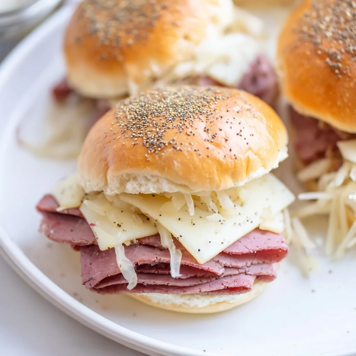 Close-up of Corned Beef Sliders with Mustard stacked on parchment, ready to serve for game day parties.