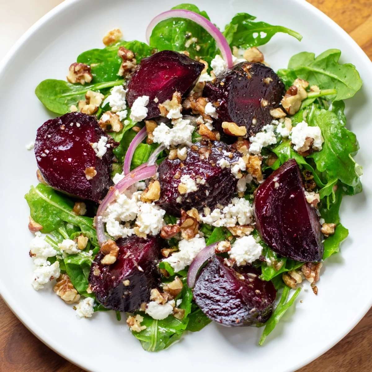 Sliced red onion and tangy balsamic dressing enhance this Roasted Beet Salad with Goat Cheese Crumbles for a fresh meal.