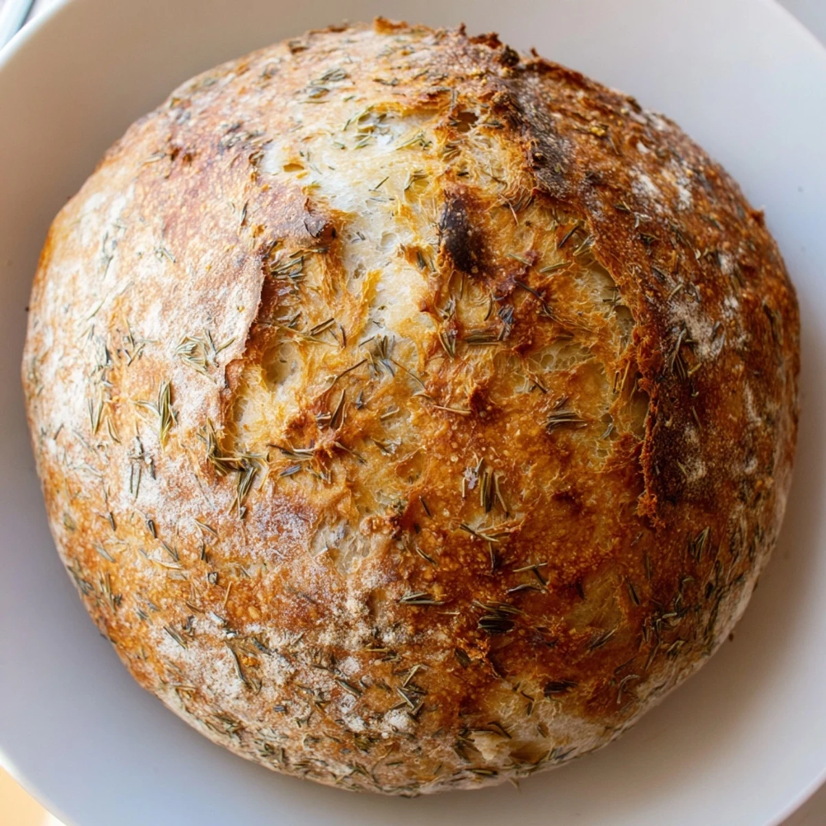 Rustic No-Knead Dill Gouda Artisan Bread loaf sits on a cooling rack, steam rising from its crisp, caramelized surface.