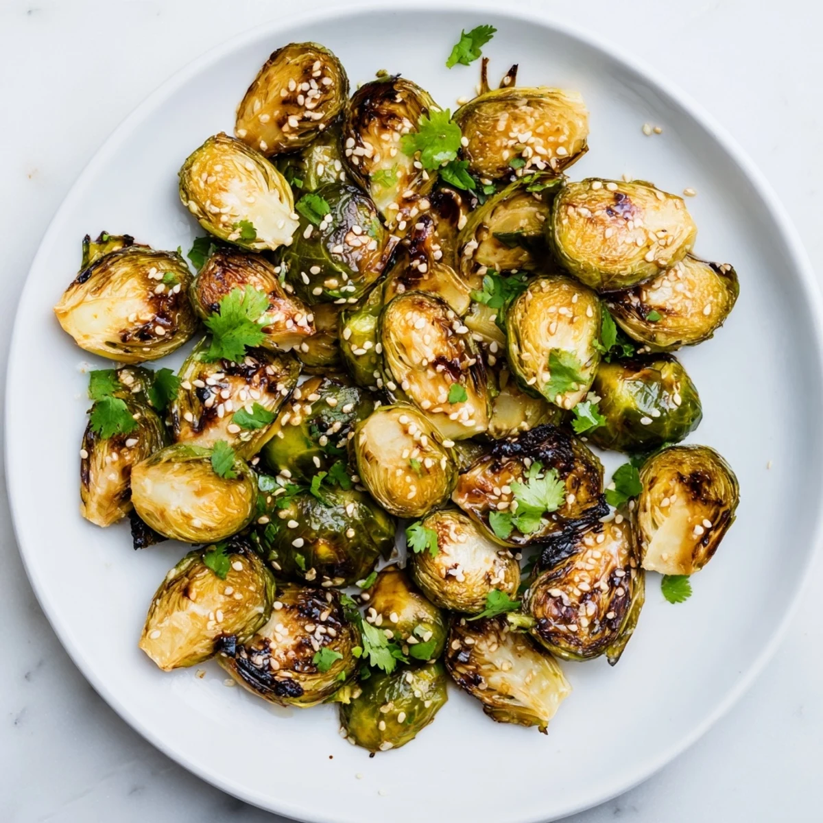 A close-up of glazed Honey Sriracha Brussels Sprouts, showcasing their crunchy edges and vibrant sauce, perfect as a vegetarian appetizer.