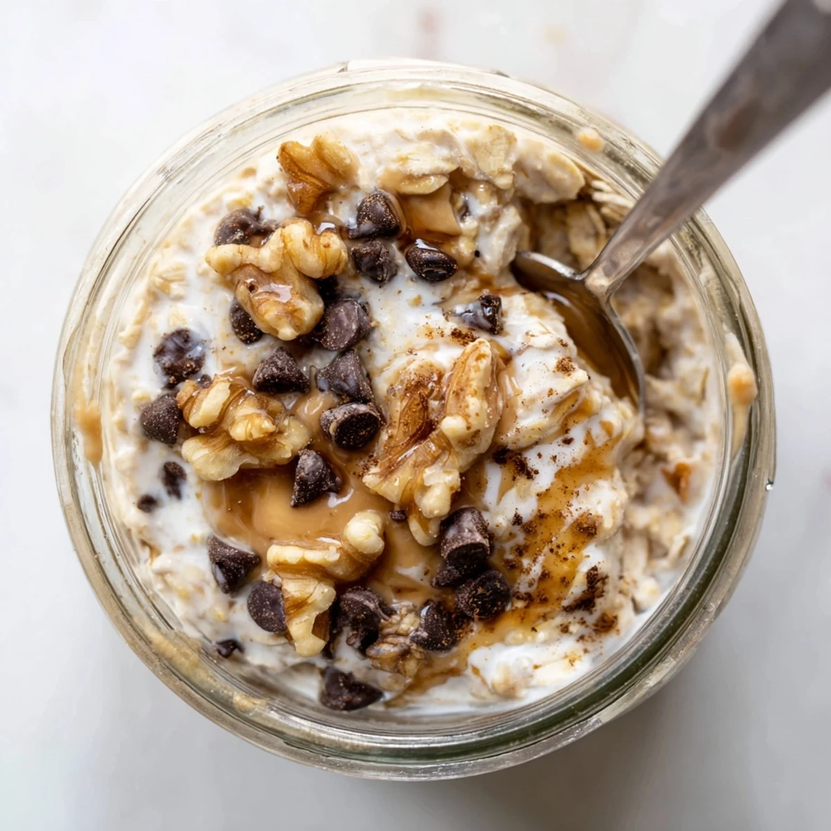 Creamy overnight oats flavored like cookie dough, with chocolate chips and chopped nuts, served chilled in a jar.