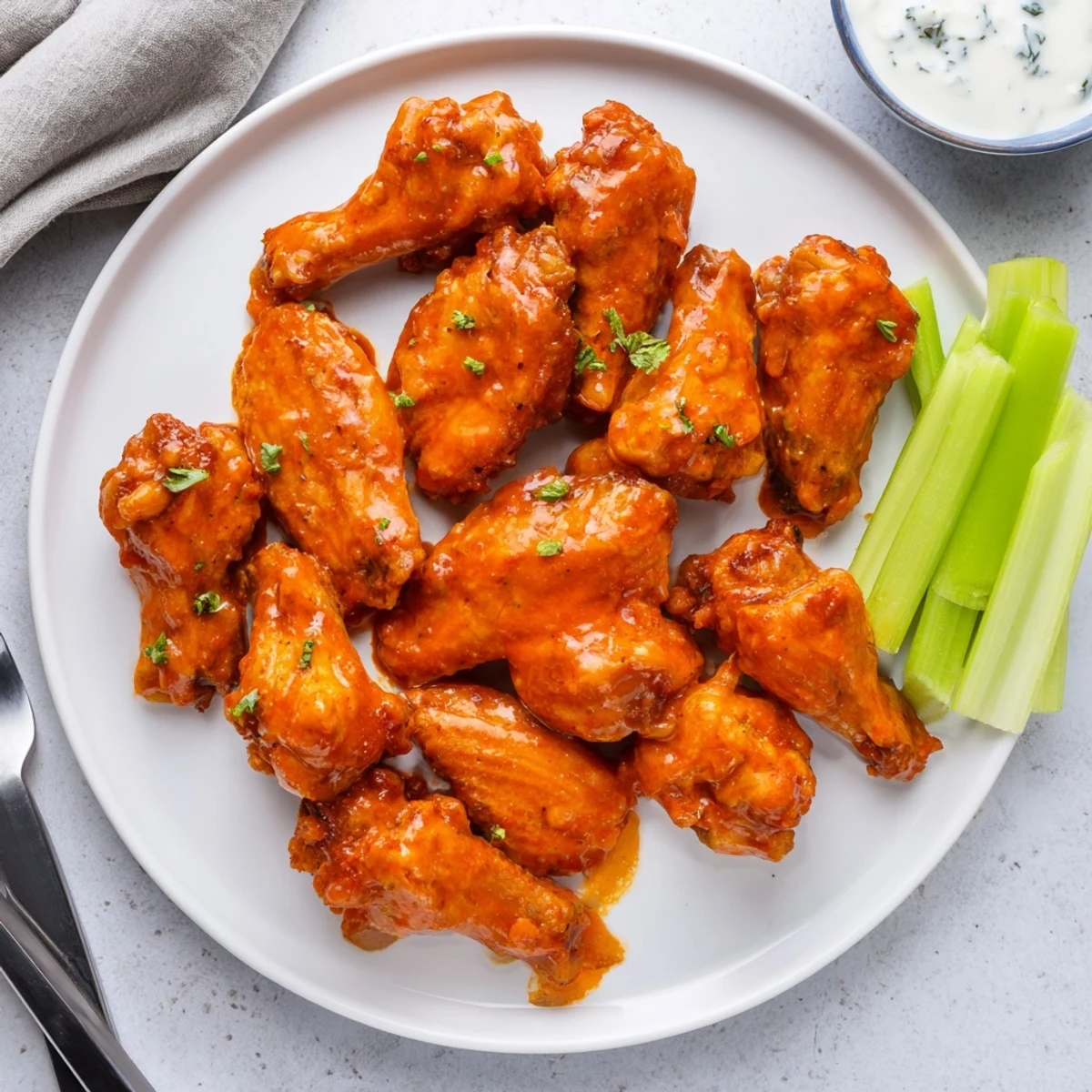 A platter of Crispy Smoked Buffalo Wings paired with crisp celery and creamy blue cheese dip.  