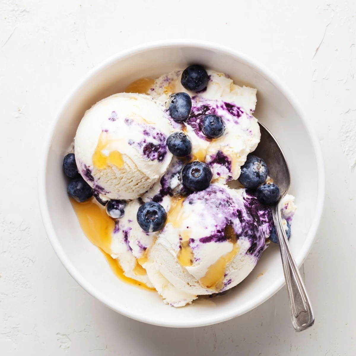 Close-up of creamy Blueberry Cottage Cheese Ice Cream being scooped from a pan, showing its smooth purple texture.