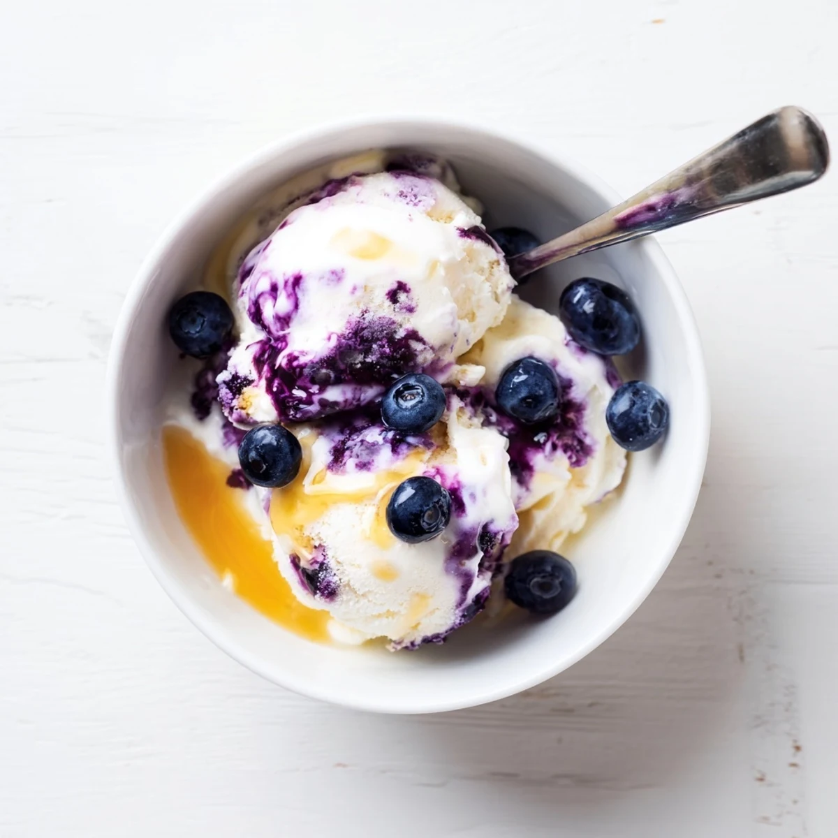 Homemade Blueberry Cottage Cheese Ice Cream served in a cone, garnished with a sprig of mint.