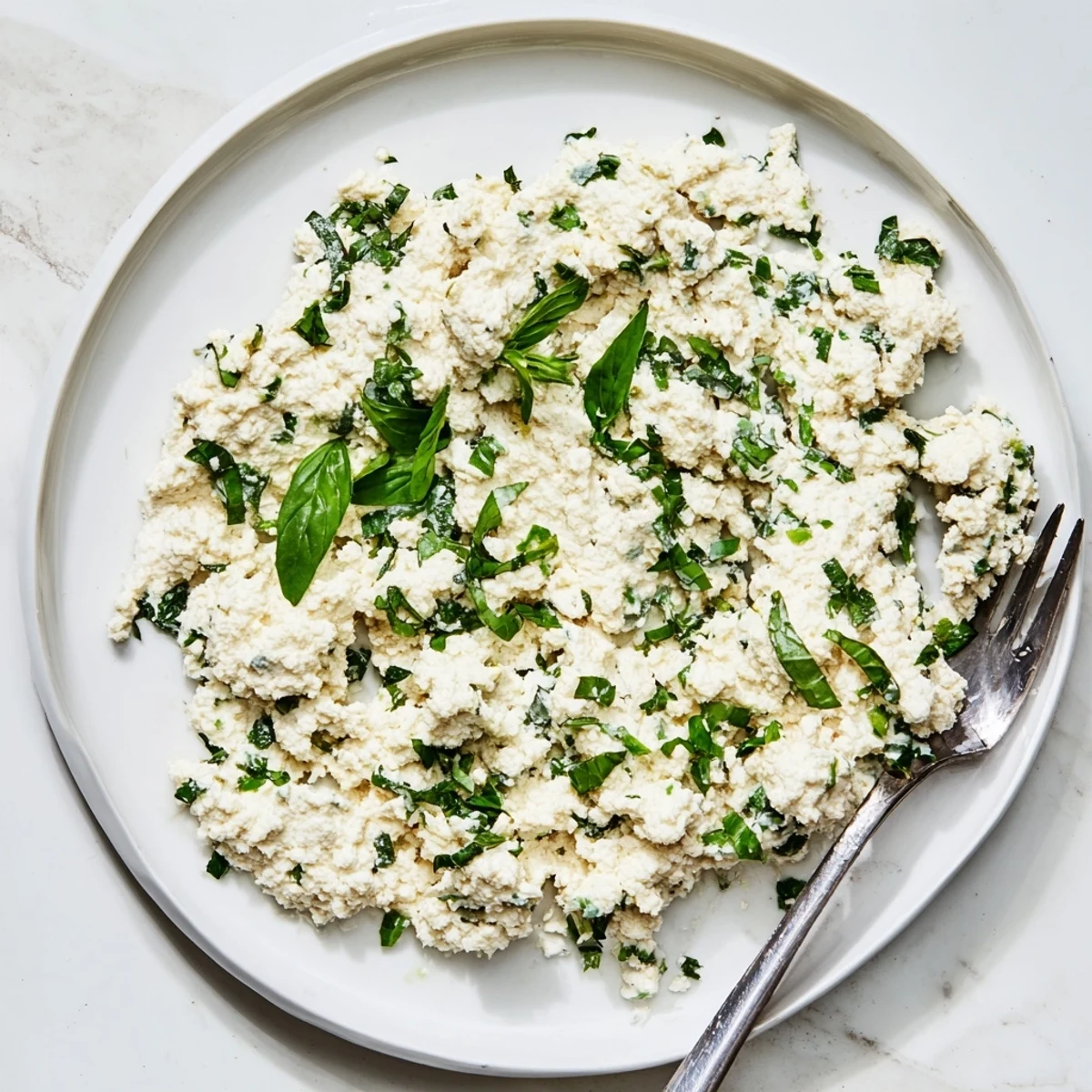 Close-up of Tofu Ricotta spread on a gluten-free cracker, showing its smooth, slightly textured vegan cheese alternative.