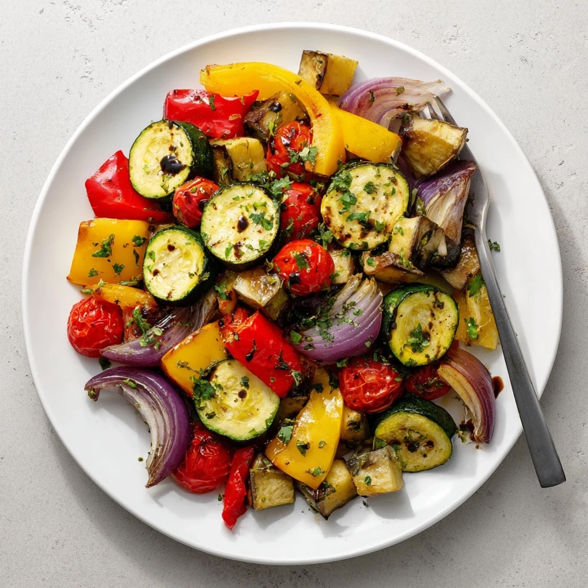 Vibrant Italian Roasted Vegetables with caramelized edges and juicy tomatoes, ready to be enjoyed as a healthy vegan side dish.