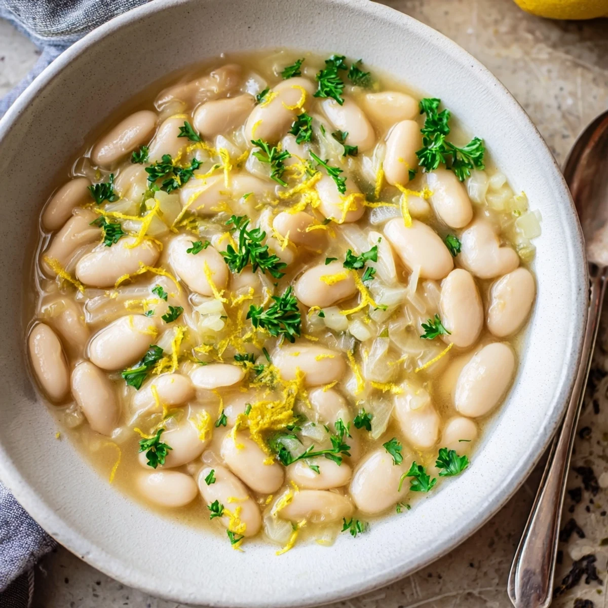 Steaming pot of Miso Butter Brothy Beans with garlic, onion, and red pepper flakes, ready to be ladled into dinner bowls.