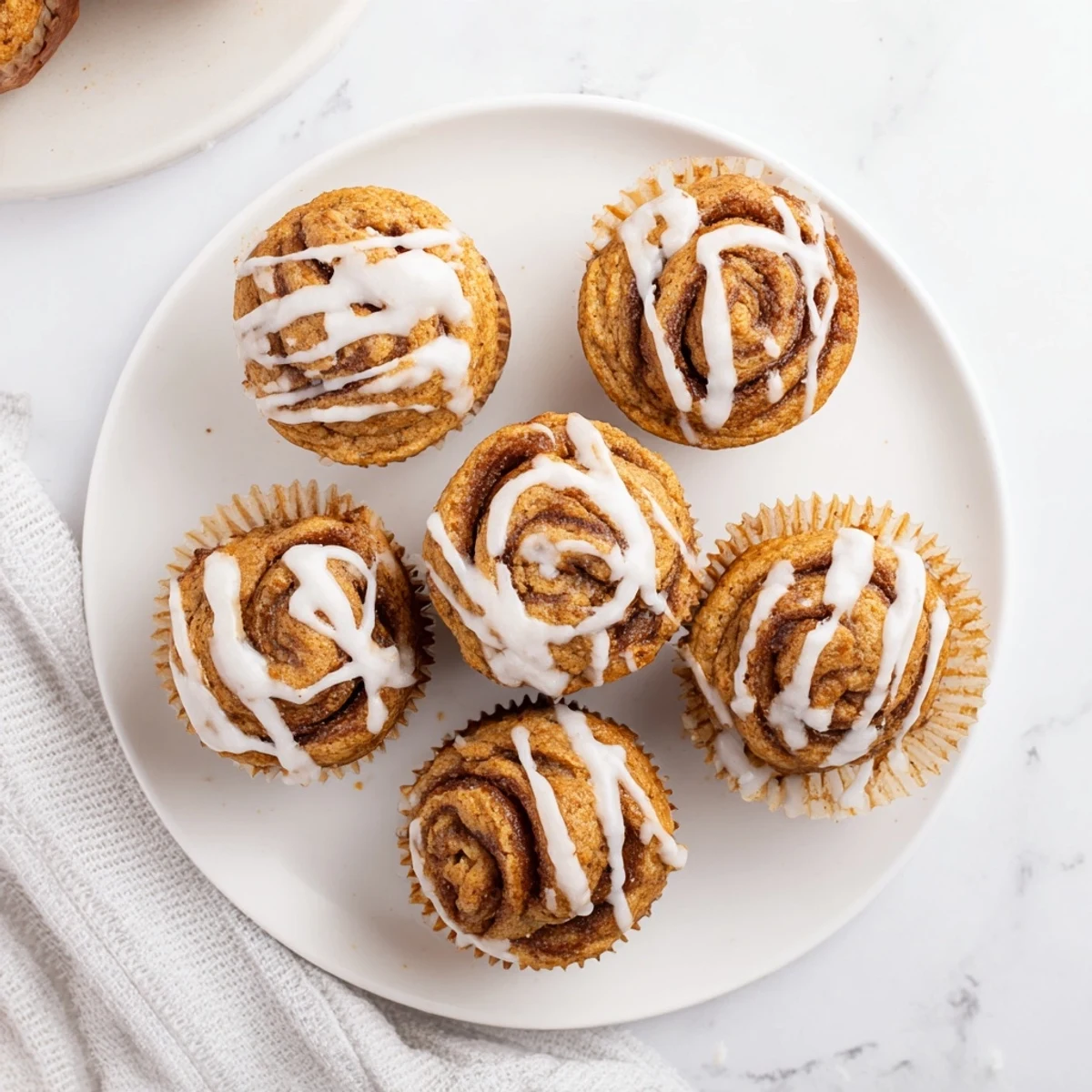 Warm cinnamon roll protein muffins with swirled spice filling ready for healthy breakfast