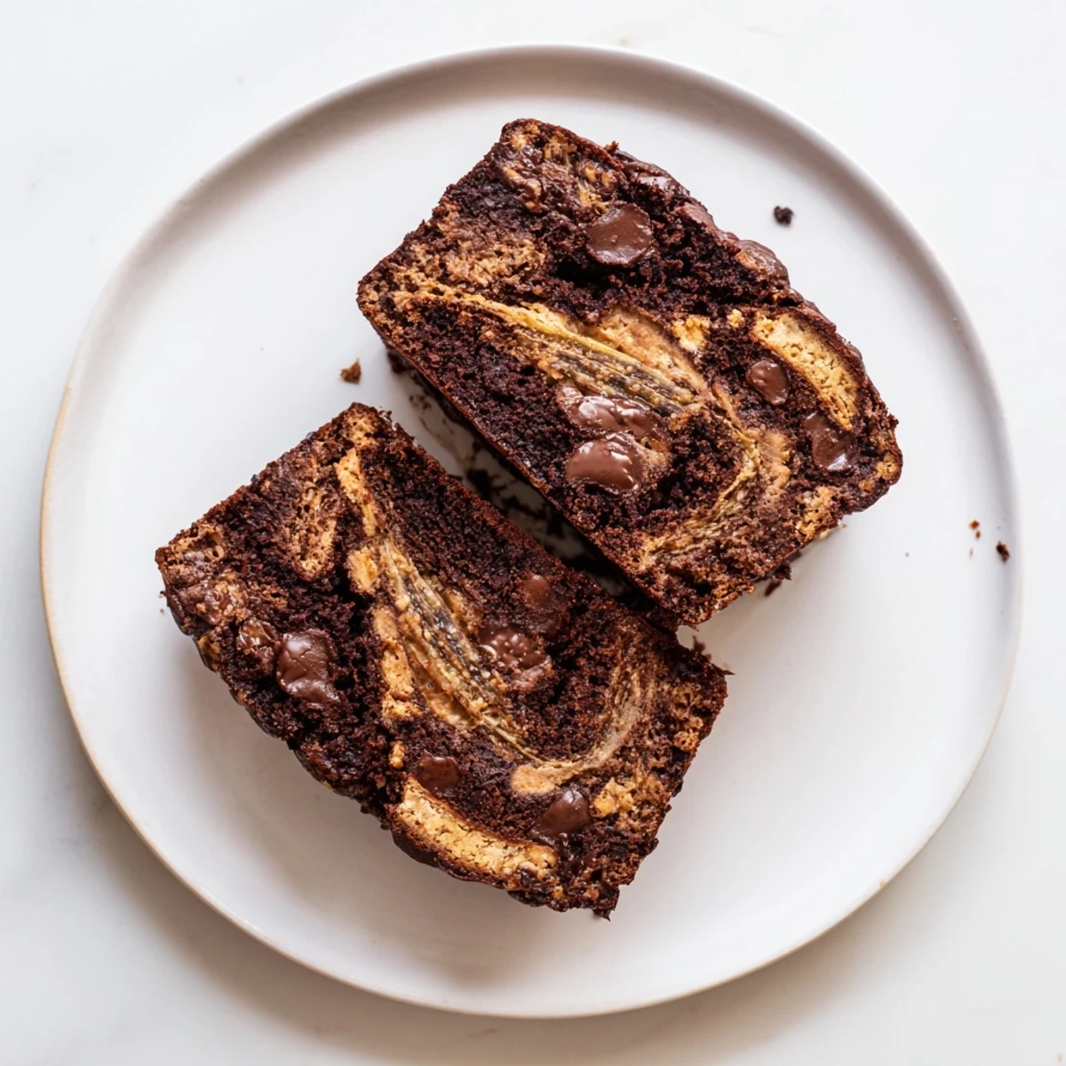 Freshly baked loaf of chocolate peanut butter banana bread with golden crust and peanut butter swirls on top