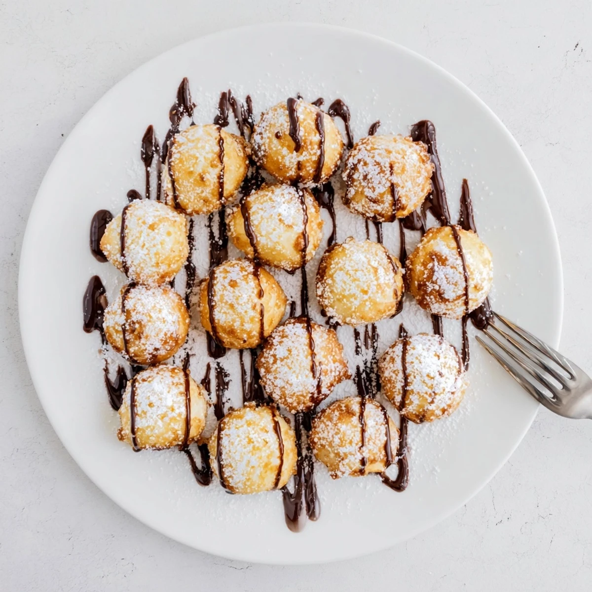 Batch of golden brown deep fried marshmallows frying in hot oil with crispy texture