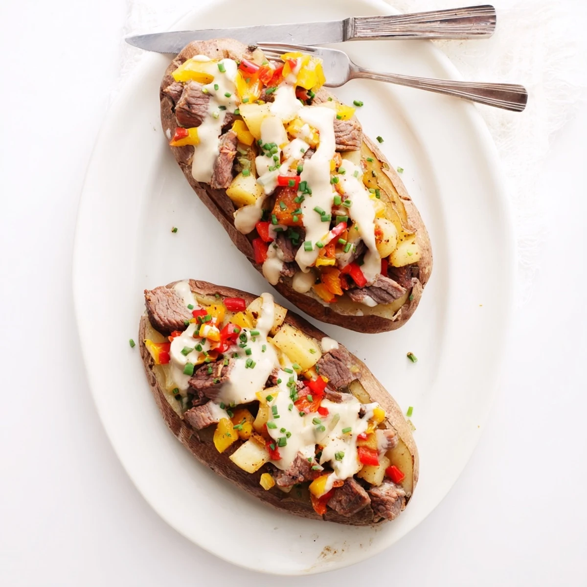 Hearty stuffed potato featuring tender steak pieces smothered in savory Parmesan cream topping