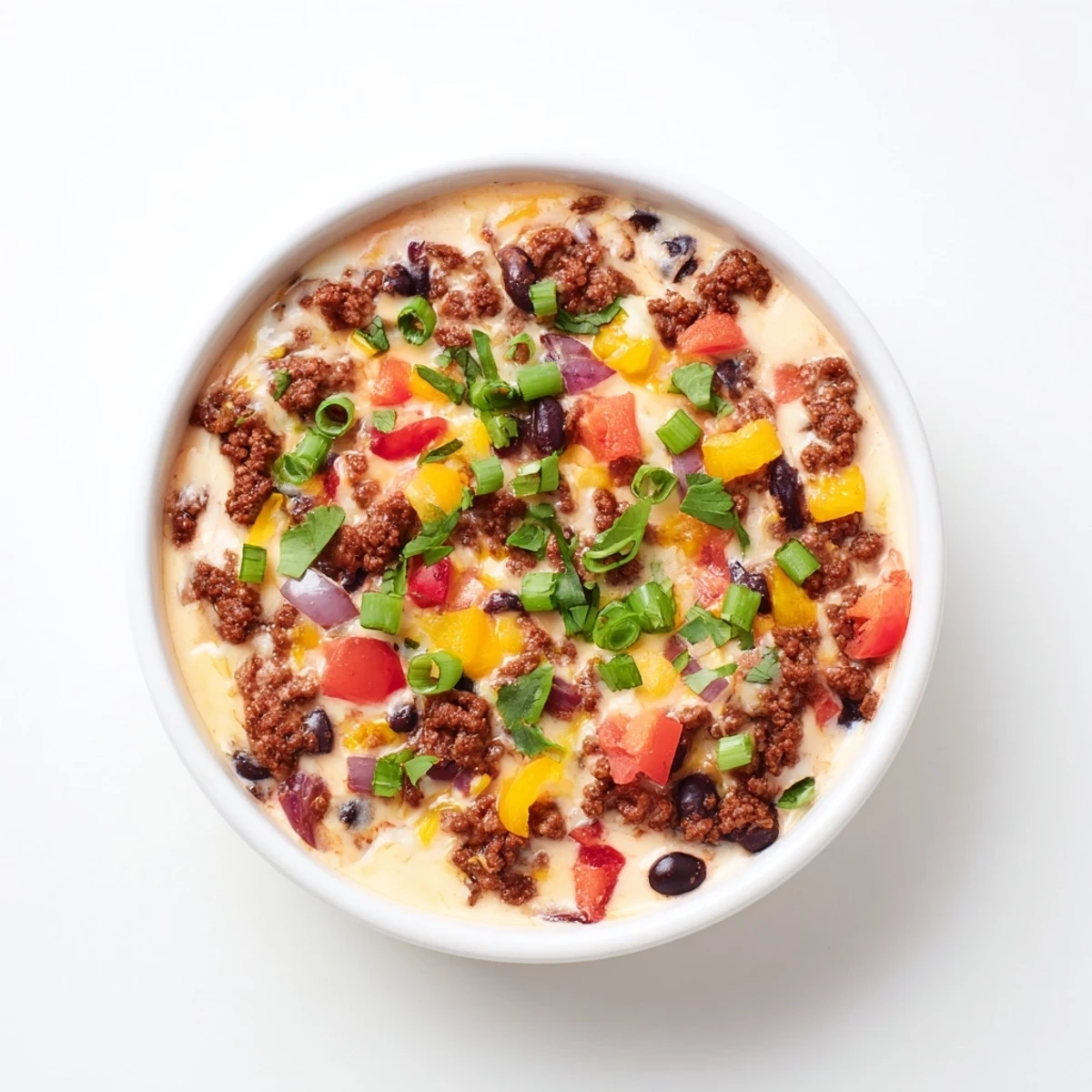 Steaming hot cowboy queso dip loaded with sausage and vegetables garnished with green onions