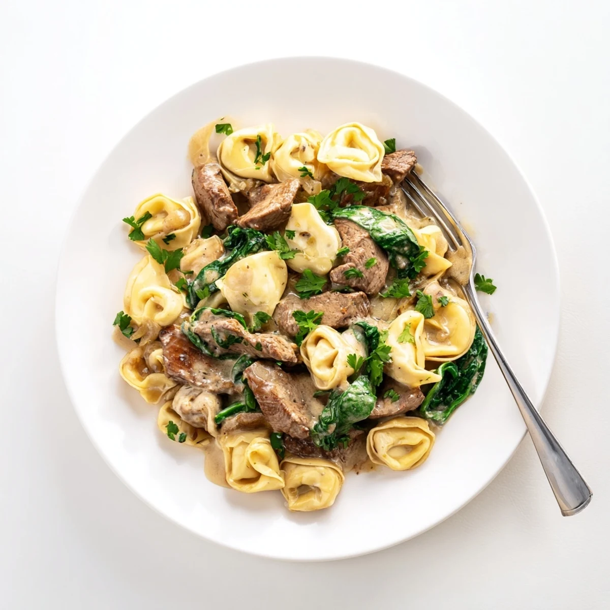 Golden garlic steak tortellini tossed in rich cream sauce with fresh spinach