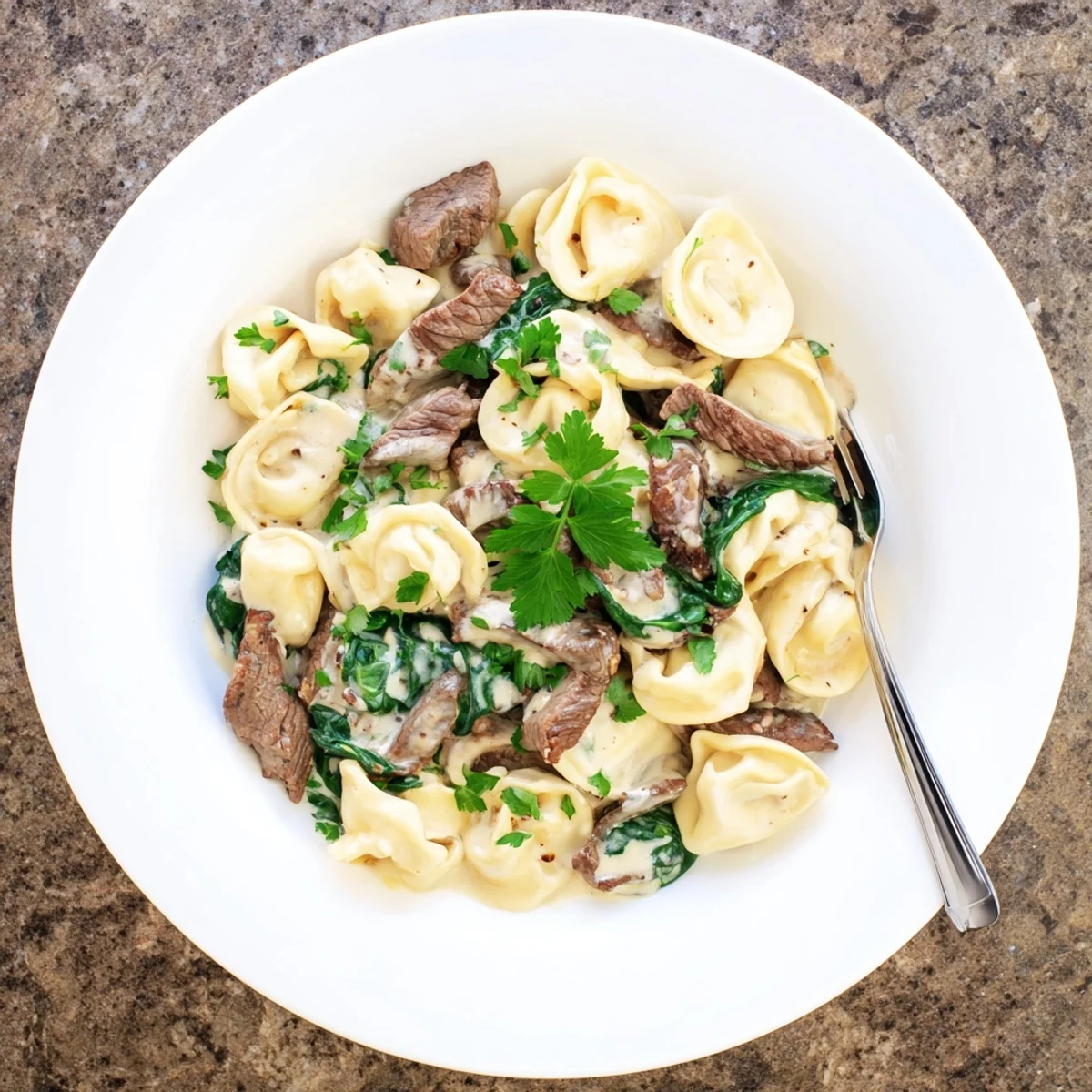 Succulent beef strips and cheese tortellini swimming in garlicky parmesan cream sauce