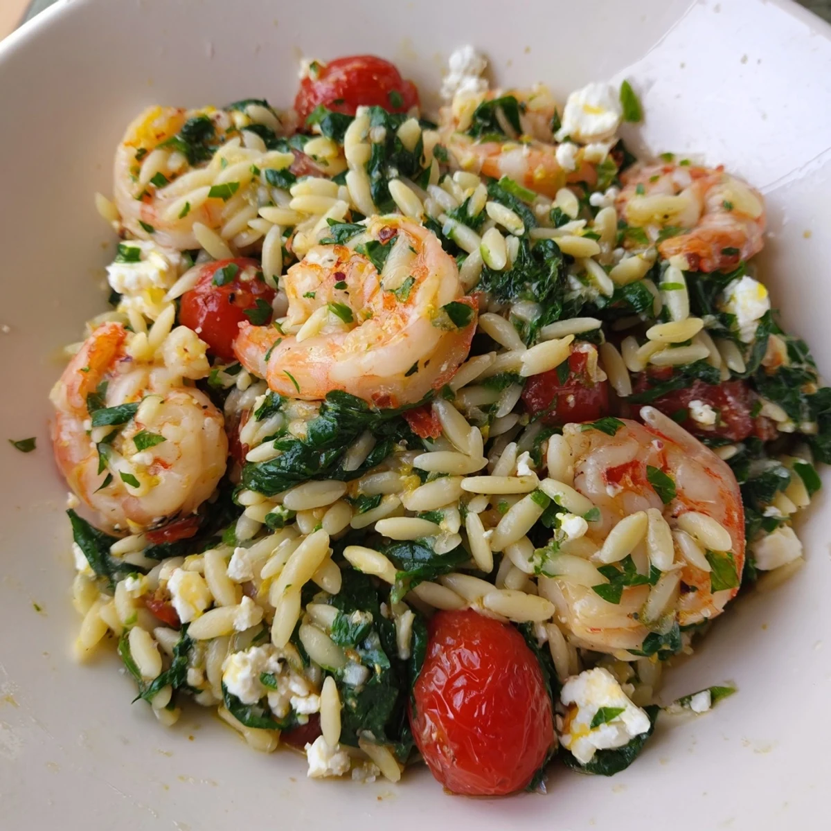 Mediterranean lemon feta orzo shrimp plated with crumbled feta and wilted spinach garnish