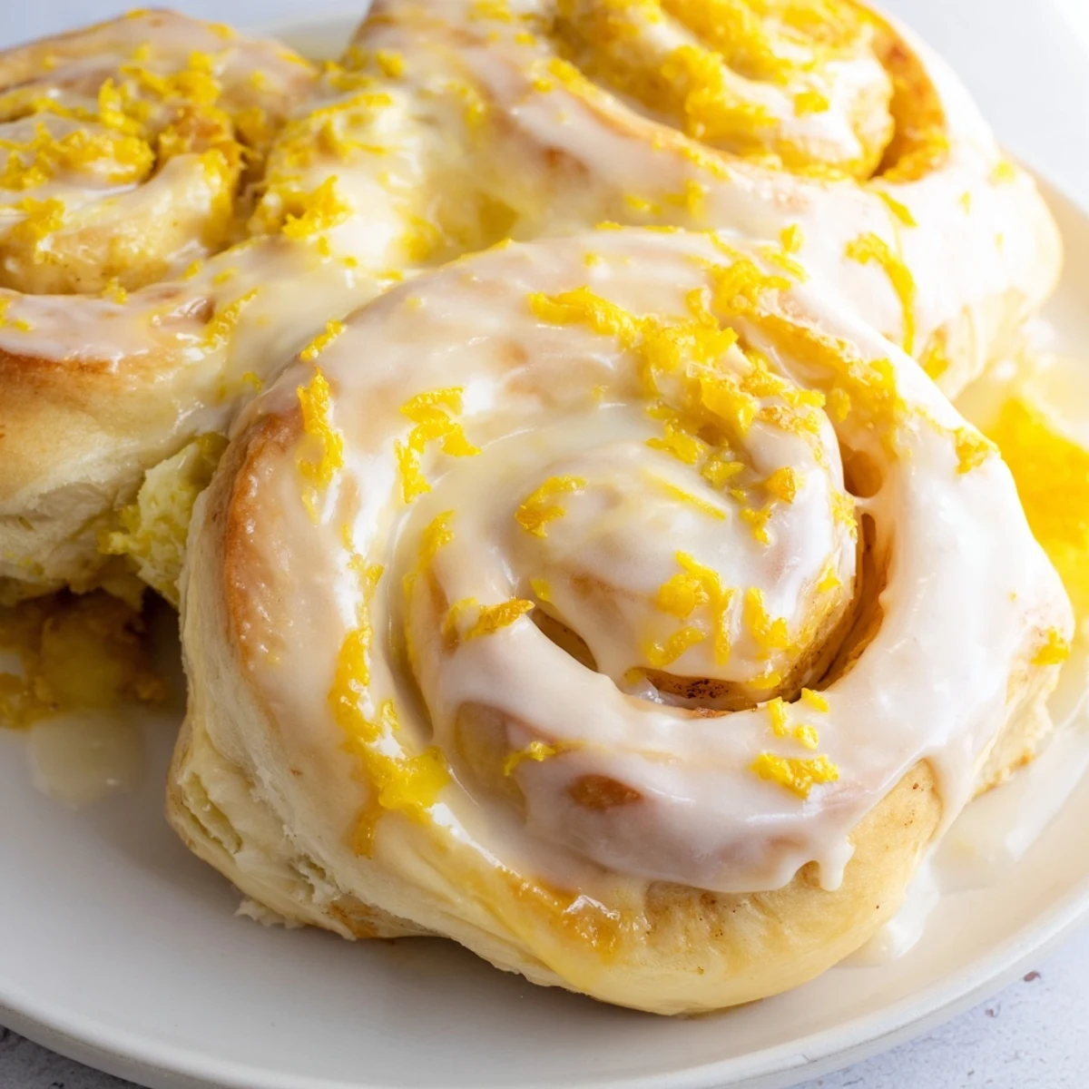 Fresh lemon rolls overflowing with sweet citrus filling and white powdered sugar glaze