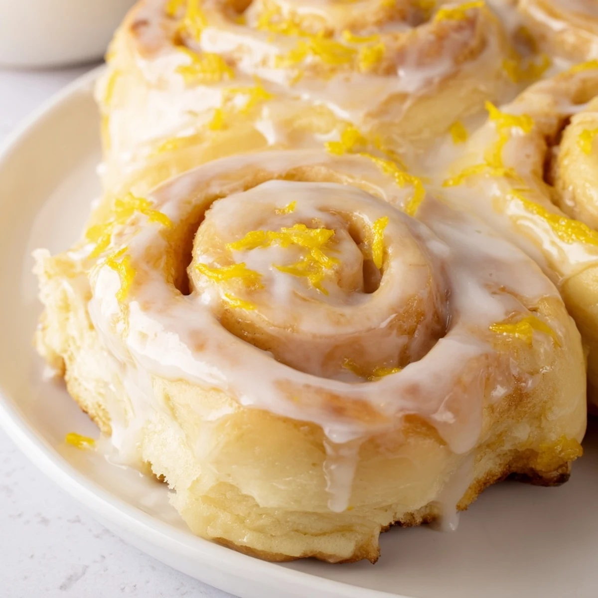 Soft homemade lemon rolls with spiral slices and zesty lemon garnish on plate