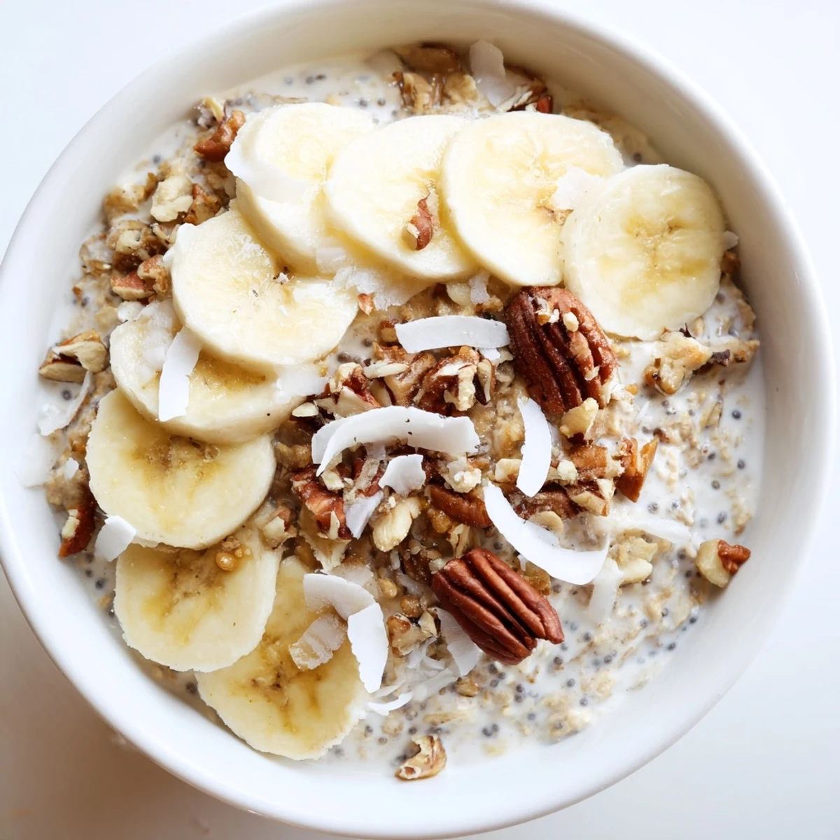 Thick Coconut Cream Pie Overnight Oats served chilled with banana slices and shredded coconut