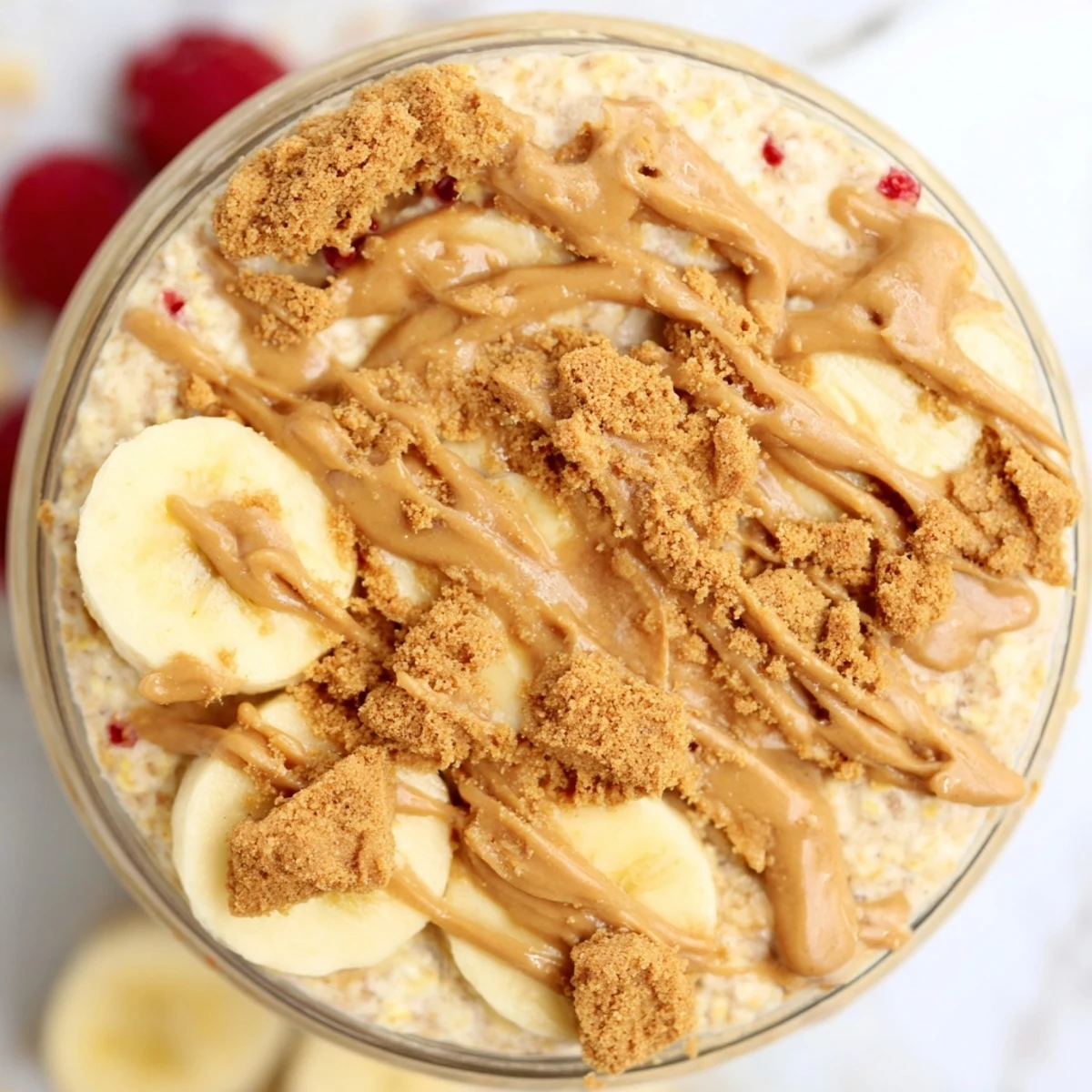 Creamy Biscoff overnight oats topped with crushed cookies in a glass jar