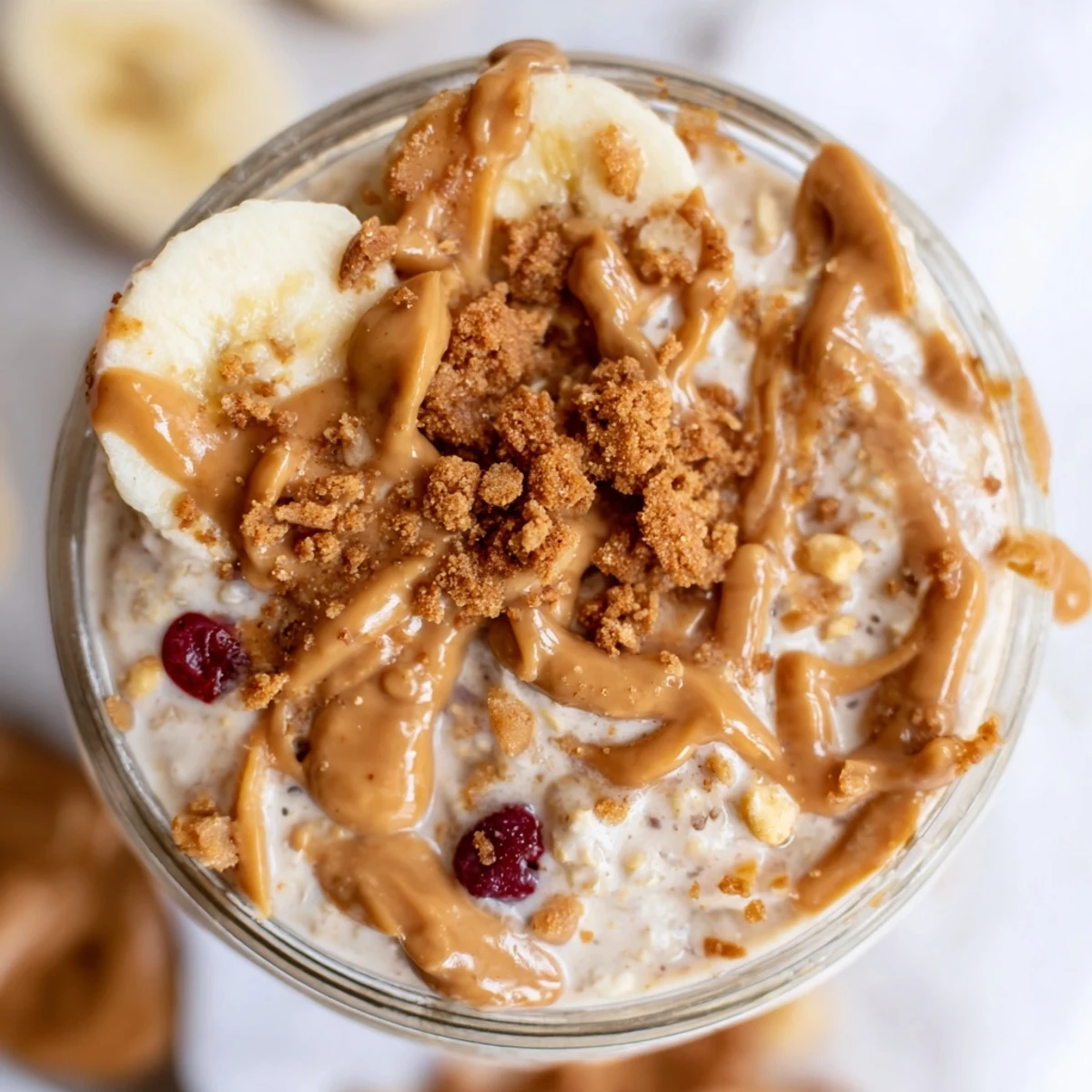 Spoon dipping into thick Biscoff overnight oats with melted cookie butter drizzle