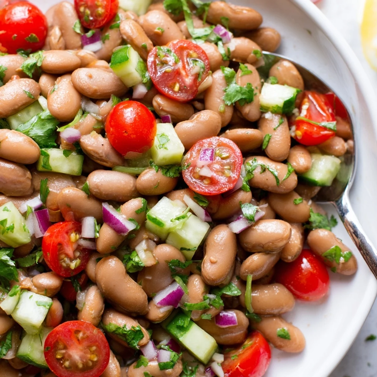 Creamy pinto beans mixed with diced peppers tomatoes and fresh cilantro