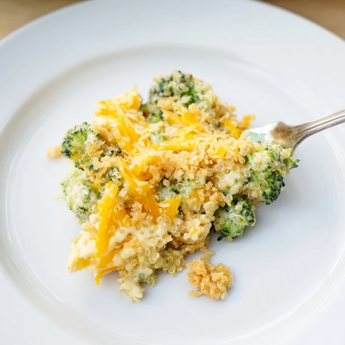 Golden creamy broccoli quinoa casserole fresh from the oven with melted cheddar topping