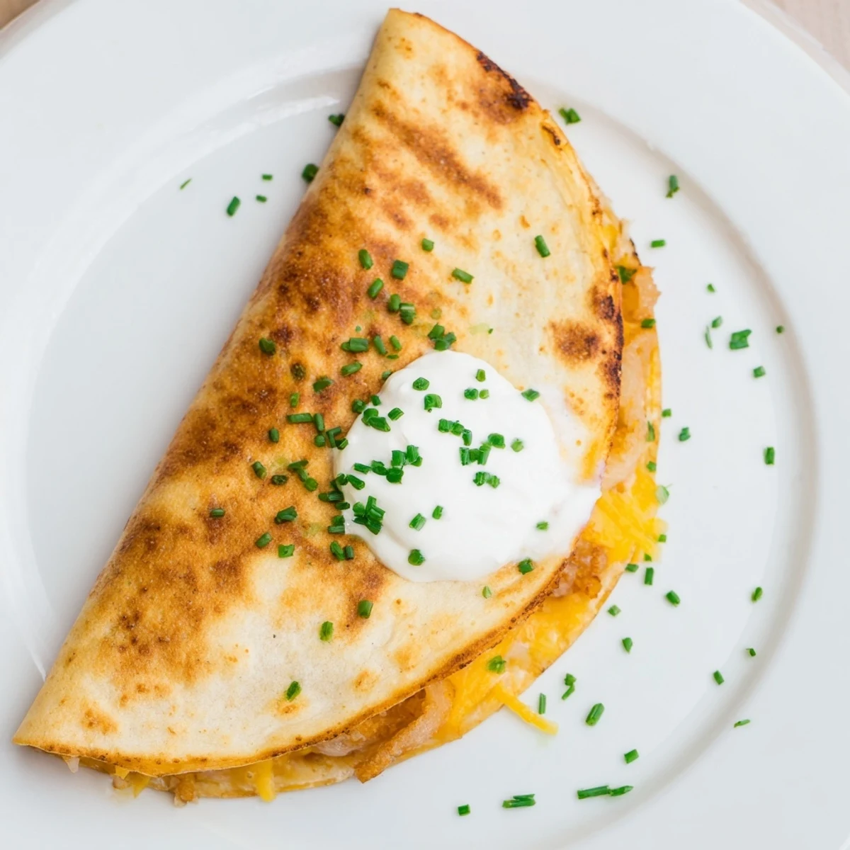 Golden tortilla quesadilla stuffed with crispy onion ring chips and melted cheddar cheese