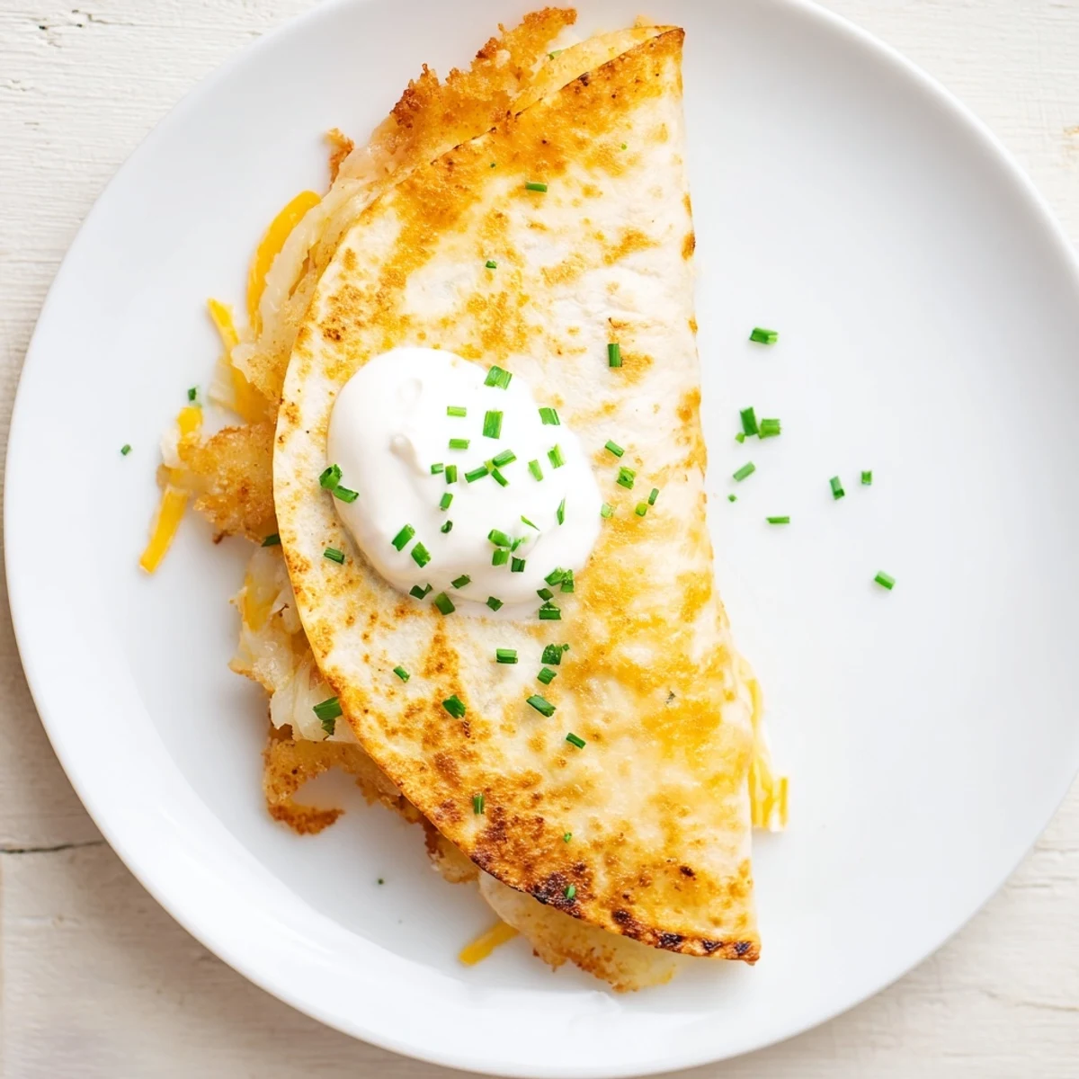 Crispy fried onion ring chips peeking from golden brown quesadilla with melted cheese layers
