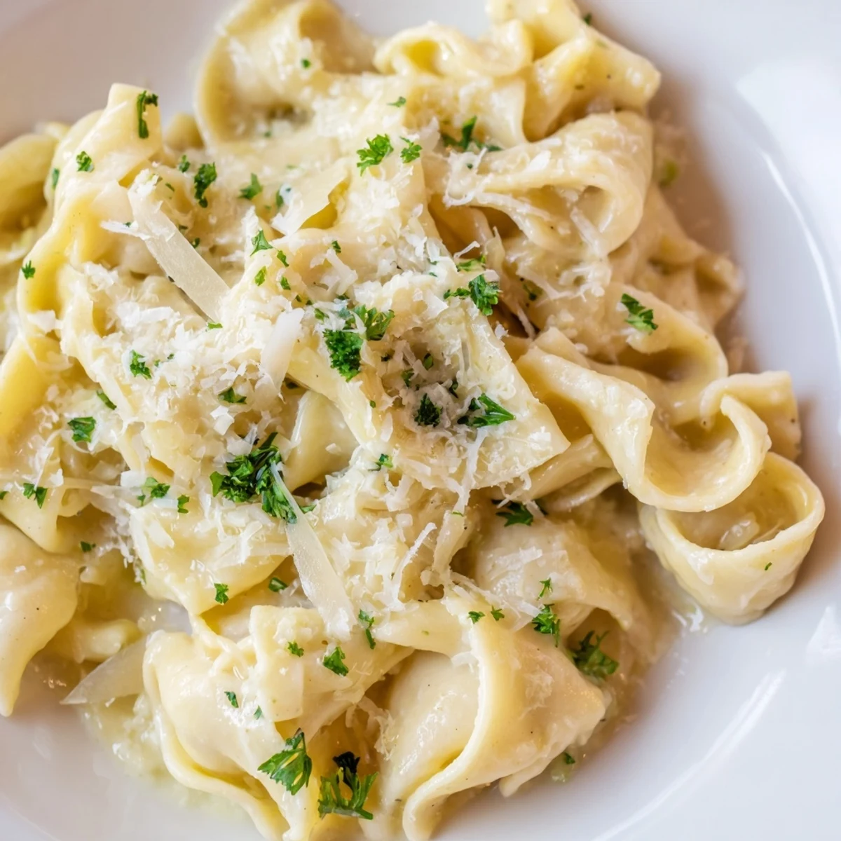 Golden creamy cafeteria noodles topped with fresh parsley and grated Parmesan cheese