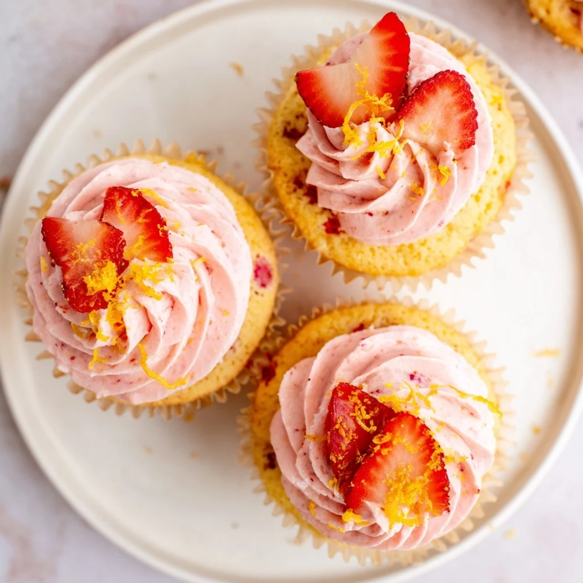 Fresh strawberry lemonade cupcakes with zesty lemon flavor and swirl buttercream garnished with strawberry slices
