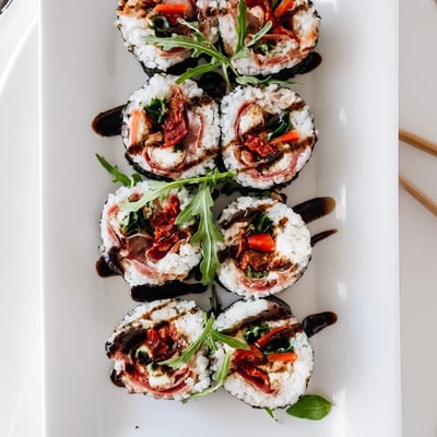 Fusion Italian sushi platter with fresh basil, sun-dried tomatoes, and arugula filling