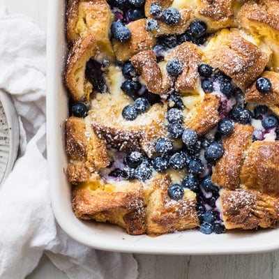 Overhead view of blueberry cream cheese croissant casserole layered with flaky pastry and sweet blueberries